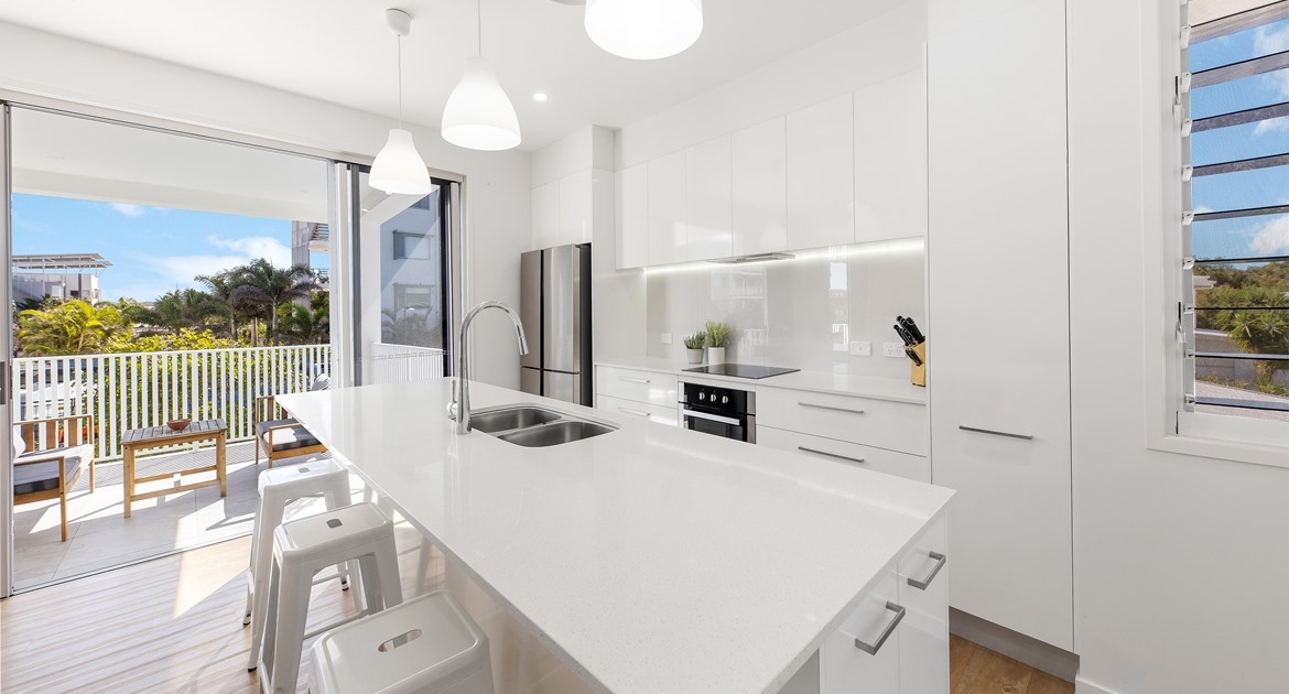 white modern kitchen with balcony in the background
