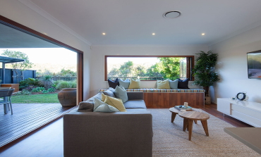 Living room sprawling out onto outdoor deck holiday home.