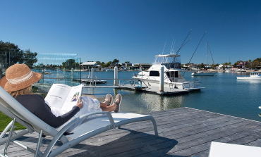 Outdoor deck with recreational fishing boats in the background at the Gaia House holiday home.