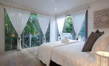 Beautiful spacious bedroom with white sheets and curtains | Prestige Holiday Homes Sunshine Coast