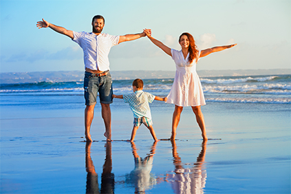 A family of three posing for a photo on a Sunshine Coast beach